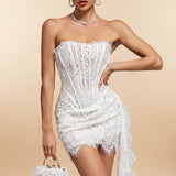 Woman wearing a white lace dress against a gray background